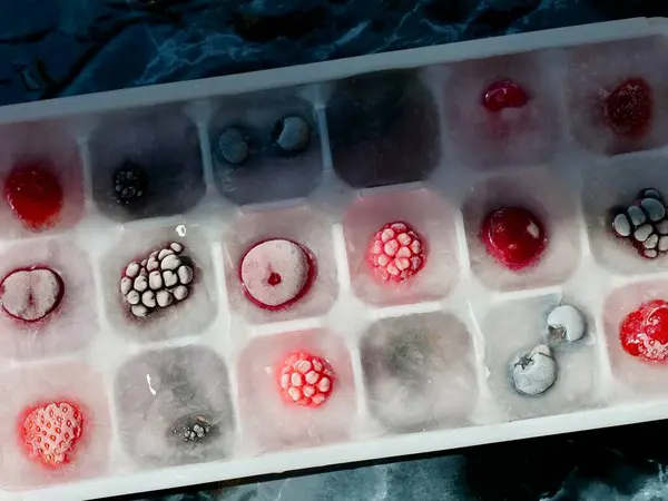 İçecekleri tazelemek veya mevsimlik kiraz, ahududu, çilek, böğürtlen, böğürtlen, yabanmersini, böğürtlen ve vitamin ve minerallerin korunması için konteynerin yanında dondurulmuş buz.