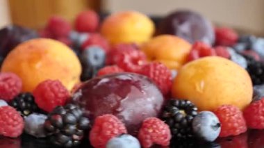 Mevsimlik yaz meyveleri kayısı, erik, ahududu, yabanmersini, böğürtlen, bahçedeki böğürtlen, yaklaşın, yavaş olun. Kadınlar böğürtlen yer.