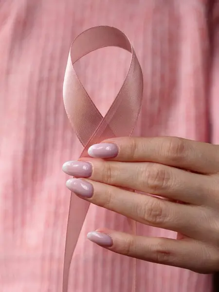 Pembe Ekim Kanser Farkındalık Ayı, kadın eli pembe kurdeleli insanların hayatını ve hastalıklarını desteklemek için hastanede. Dikey 