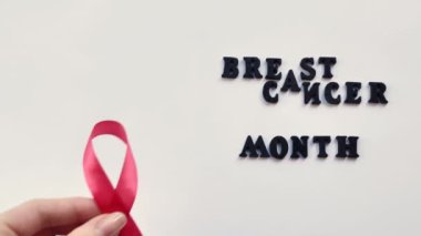 Meme kanseri Kadınlar Ayı kavramı. Beyaz arka planda pembe sembol kurdelesi