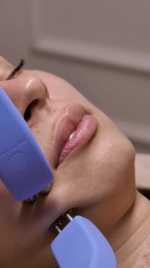 Yüzün oval kısmını iğne yapmadan kaldırmak için mikro akım. Güzellik uzmanı kas yorgunluğunu azaltmak, elastane kolajeni üretimini canlandırmak ve deri turgor 'unu geliştirmek için mikroskobik masaj aleti kullanır.