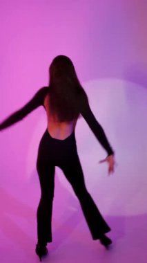 Neon mor arka planda Bachata Lady Style, genç esmer beyaz kadın dans eden kadın koreografisi. dikey, 