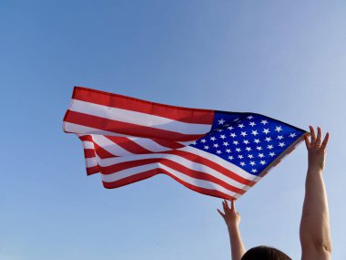 Bağımsızlık Günü bayrağı, rüzgarda dalgalanan mavi gökyüzünün arka planına karşı. Kapat.