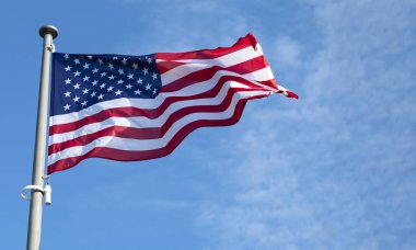 Flag of United States waving in the wind at sunny day.