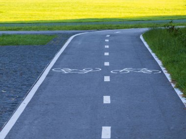 Güneşli bir yaz gününde Boyanmış Bisiklet Sembolleri ve Kesik Çizgilerle Adanmış Bisiklet Yolu