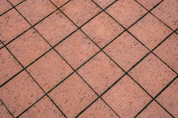 Koyu harç çizgileri olan kırmızı kare karoların çapraz görünümü