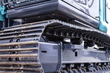 Büyük bir kazıcının iz ve şasi sisteminin ayrıntılı görünümü, ağır inşaat ve toprak taşıma görevlerinde kullanılan mekanik parçaları vurguluyor.