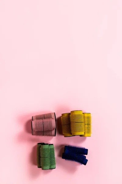 Pembe Arka Planda Farklı Boyutlarda Renklerde Cırt Cırt Bigudiler — Stok fotoğraf