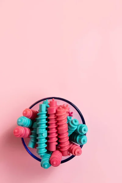 Pembe Arka Planda Mavi Cam Bir Kasede Renkli Spiral Plastik — Stok fotoğraf