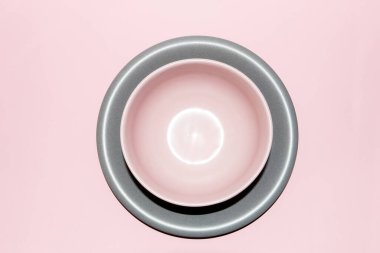 Pembe arka planda gri bir tabakta pastel pembe kase. Üst görünüm.