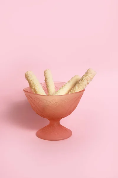 Coconut wafer in a pink glass icecream cup on pink background