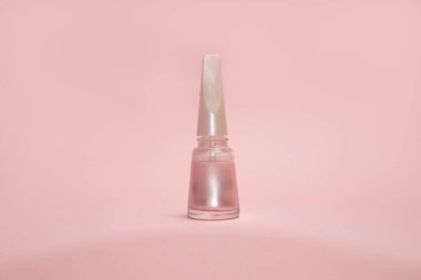 Pembe arka planda bir şişe pembe oje.