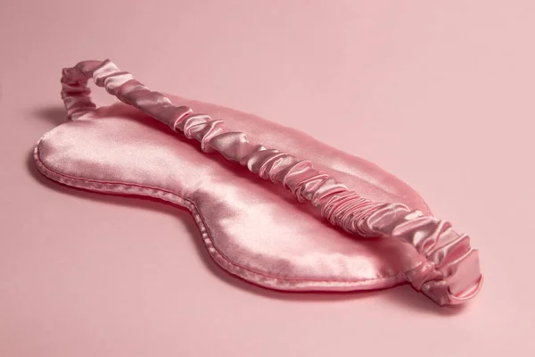 粉红背景的粉红丝质睡眠面罩 — 图库照片