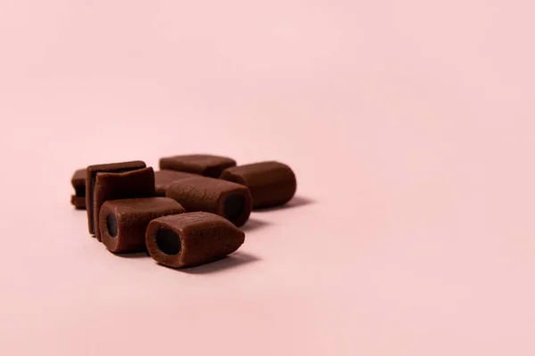 Pembe Arka Planda Çikolatalı Meyan Kökü Şekeri Sığ Dof — Stok fotoğraf
