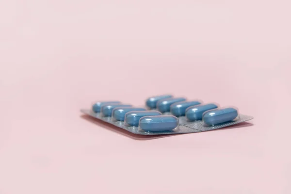 Niebieskie Tabletki Blistrze Różowym Tle — Zdjęcie stockowe