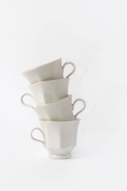 Beyaz arka planda altın kaplamalı beyaz kahve fincanları ve çay tabakları. Üst görünüm.