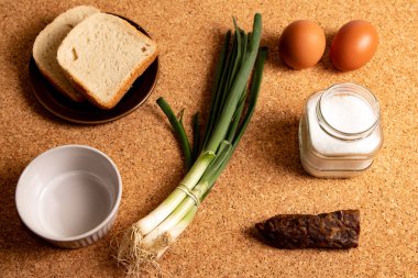 Food background. Bread, eggs, spring green onions, salt, and sausage