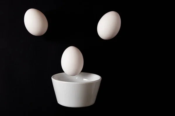 Ovos Galinha Branca Flutuando Acima Uma Tigela Cerâmica Fundo Preto — Fotografia de Stock