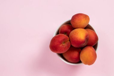 Pembe arka planda taze olgun kayısılar. Üst görünüm.