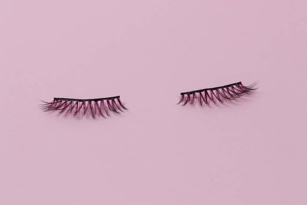 Фальшивые розовые и черные веки на розовом фоне