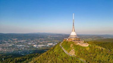 Sunny evening at Jested Mountain with unique building on the summit. Liberec, Czech Republic. Aerial view from drone. clipart