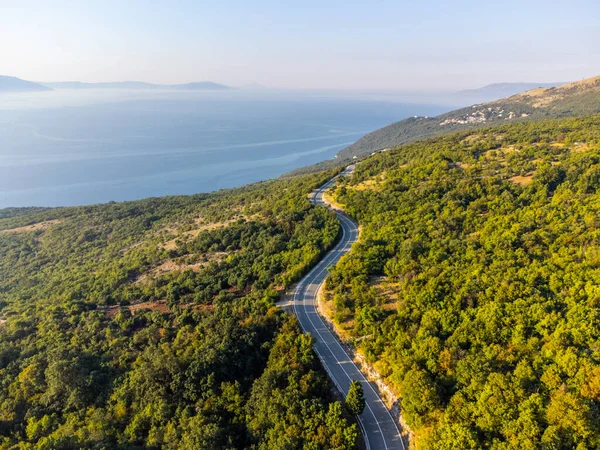 Stock image Winding coastal road, rocky cliffs and blue sea in sunny morning. Istria, Croatia