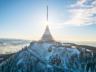 Jested mountain with modern hotel and TV transmitter on the top, Liberec, Czech Republic. Sunny winter day with snowy landscape. Aerial view from drone. clipart