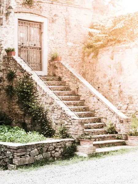 Old stone staircase and wooden door at the Tuscan house, Italy