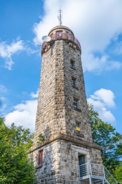 Rising against a blue sky, the stone lookout tower on Prosecsky Hreben in the Jizera Mountains stands as a point of interest for visitors seeking panoramic views. clipart