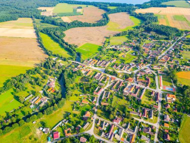 This aerial perspective showcases the picturesque rural landscape around Trebon, Czechia, highlighting the harmonious blend of winding rivers, lush fields, and charming village homes nestled in the clipart