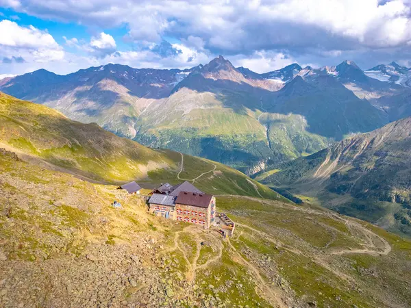 stock image The Breslauer Hut rests atop a rugged landscape in the Otztal Alps, providing stunning views of surrounding peaks and valleys. Cloud formations add depth to the alpine scenery, inviting exploration.