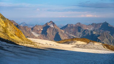 The Taschachferner Glacier stretches across the Otztal Alps in Austria, revealing its vast icy expanse under clear skies. Majestic mountain peaks surround the glacier, showcasing stunning alpine clipart