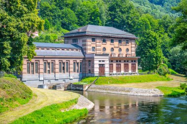 This scenic hydroelectric power plant, located in Czechia, showcases its historic architecture and tranquil riverside setting, surrounded by lush greenery and natural beauty. clipart