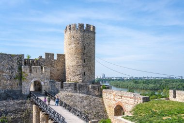 Visitors explore Despots Gate and Dizdar Tower at Belgrade Fortress, enjoying panoramic views of the river and cityscape on a sunny day in Serbias capital. clipart