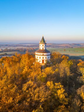 The Baroque hunting chateau Humprecht rises amidst vibrant autumn foliage, basking in the golden hues of sunrise over the Bohemian Paradise, above Sobotka in Czechia. clipart