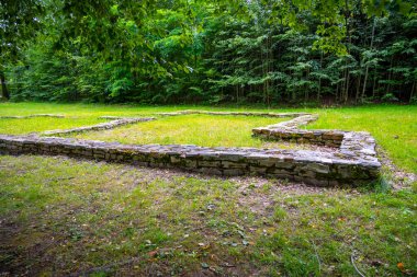 The remnants of Zizkas mansion are visible at the archaeological site in Trocnov, surrounded by lush greenery and forest, marking the birthplace of the famed Hussite military leader. clipart