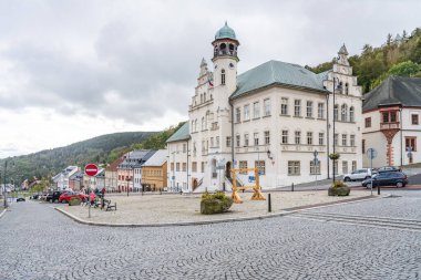 Jachymovs town hall stands majestically, showcasing its architectural beauty against a backdrop of rolling hills. Cobblestone streets invite exploration in this charming Czech town. clipart