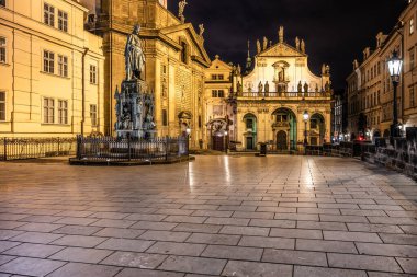 Illuminated square features the Charles IV statue surrounded by historic architecture. Visitors stroll through the cobblestone paths under the night sky, enjoying the tranquil atmosphere. clipart