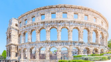 The Roman amphitheatre in Pula, located on the Istria Peninsula, stands as a remarkable symbol of ancient engineering. Visitors explore its impressive arches and stone walls. clipart