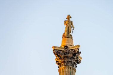 Nelsons Column in Trafalgar Square showcases the statue of Vice-Admiral Horatio Nelson, honoring his victory at the Battle of Trafalgar against a clear sky backdrop. clipart