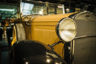 Yuvarlak farlı klasik Vintage Car 'ın ön görüntüsü. Kaliteli fotoğraf. Klasik klasik bir arabanın ön görüntüsü, iki büyük yuvarlak farın hakim olduğu simetrik tasarımını gözler önüne seriyor.