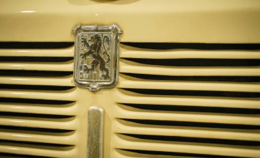 Vintage Vehicle Grille 'e yakın çekim ve klasik bir aracın detaylı yakın çekimi merkezinde güç ve prestiji sembolize eden karmaşık bir şekilde tasarlanmış aslan amblemi bulunur. Izgaralar.