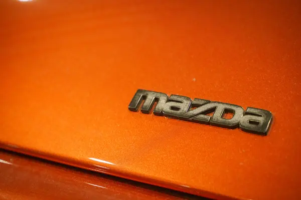 stock image Mazda Logo on Orange Car Hood. High quality photo