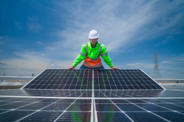 Çatıda yürüyen mühendisler ekipman kutusu ve telsiz iletişimiyle güneş hücresi panelini inceler ve kontrol ederler. Güneş pili akıllı ızgara ekolojik enerji alternatif enerji güneş ışığı enerji fabrikası konseptidir.