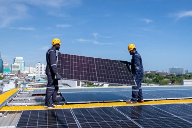 Çatıda yürüyen mühendisler ekipman kutusu ve telsiz iletişimiyle güneş hücresi panelini inceler ve kontrol ederler. Güneş pili akıllı ızgara ekolojik enerji alternatif enerji güneş ışığı enerji fabrikası konseptidir.