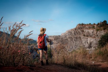 Gezginler ya da gezginler sırt çantası taşıyan gezginler, yürüyüş direkleri uzak mesafeye bakar ve muhtemelen yürüyüş ve yol keşfi ve tatil eko-turizmi kavramına rehberlik ederler..