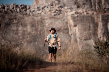 Gezginler ya da gezginler sırt çantası taşıyan gezginler, yürüyüş direkleri uzak mesafeye bakar ve muhtemelen yürüyüş ve yol keşfi ve tatil eko-turizmi kavramına rehberlik ederler..