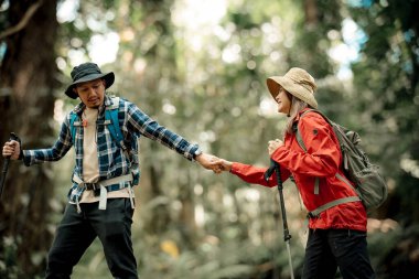 Gezginler ya da gezginler sırt çantası taşıyan gezginler, yürüyüş direkleri uzak mesafeye bakar ve muhtemelen yürüyüş ve yol keşfi ve tatil eko-turizmi kavramına rehberlik ederler..