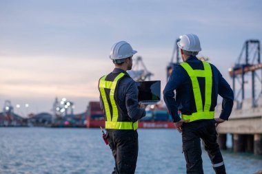 Endüstriyel mühendisler, küresel ticaret ve tedarik zinciri ihracat çevresinin sorumlu küresel ekonomiyi izleyerek liman vinçlerini yükleyip boşaltırlar..