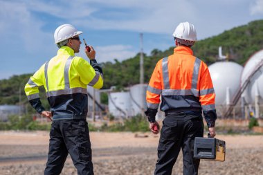 Çevre mühendisi veya işçiler, sistemlerin etkin çevre düzenlemelerini sağlamak için büyük bir endüstriyel atık su veya kirlilik izleme ve bakımı boyunca atık suyu inceleyen işçiler.